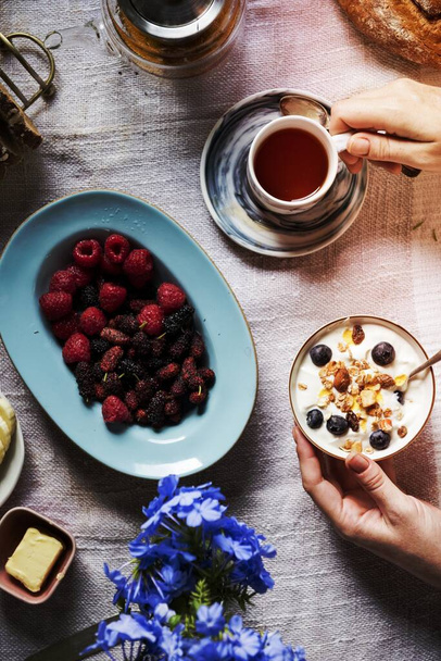 Kobieta korzystających jagody i jogurt na śniadanie - Zdjęcie, obraz