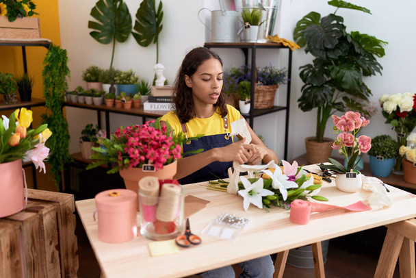 Young african american woman florist make bouquet of flowers at flower shop - Foto, imagen