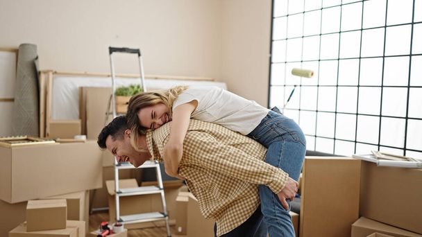 Чоловік і жінка пара тримає дівчину на спині в новому будинку
 - Фото, зображення