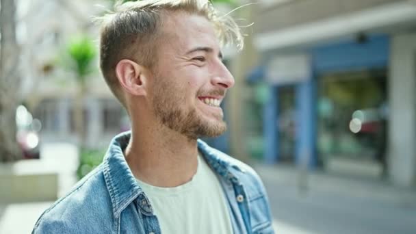 Young caucasian man smiling confident looking to the side at street - Filmmaterial, Video