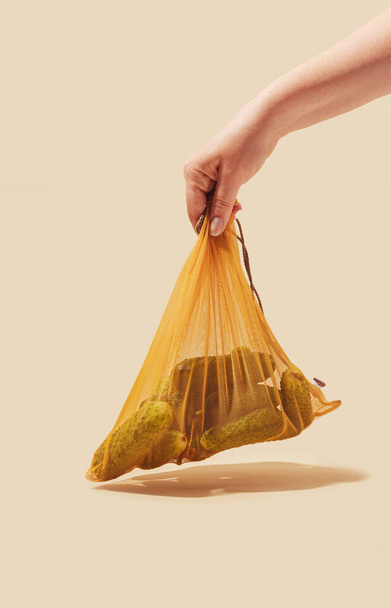 Pepinos armazenados em uma sacola ecológica, promovendo o uso consciente e sustentável. Esta imagem representa a importância das escolhas eco-conscientes e incentiva o comportamento responsável do consumidor - Foto, Imagem