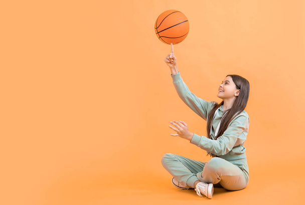 teen basketball girl on background advertisement. photo of teen basketball girl with ball. teen basketball girl isolated on yellow. teen basketball girl in studio. - Valokuva, kuva