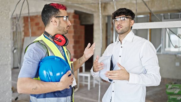 Dois homens construtor e arquiteto de pé juntos falando no canteiro de obras - Foto, Imagem