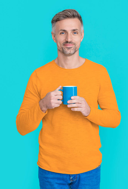 happy mature man at coffee break on background. photo of mature man at coffee break. mature man at coffee break isolated on blue. mature man at coffee break at studio. - Фото, зображення