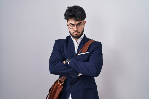 Hispanic man with beard wearing business clothes skeptic and nervous, disapproving expression on face with crossed arms. negative person.  - Photo, image