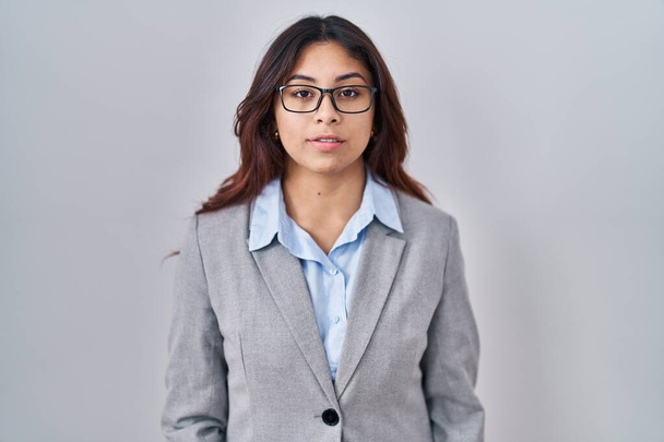 Hispanic young business woman wearing glasses relaxed with serious expression on face. simple and natural looking at the camera.  - Photo, Image