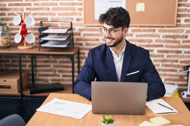 Young hispanic man business worker using laptop working at office - Fotó, kép