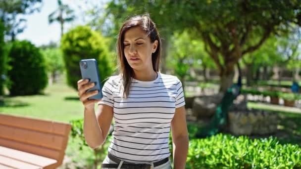 Donna mediorientale sorridente fiducioso fare selfie con il telefono al parco - Filmati, video