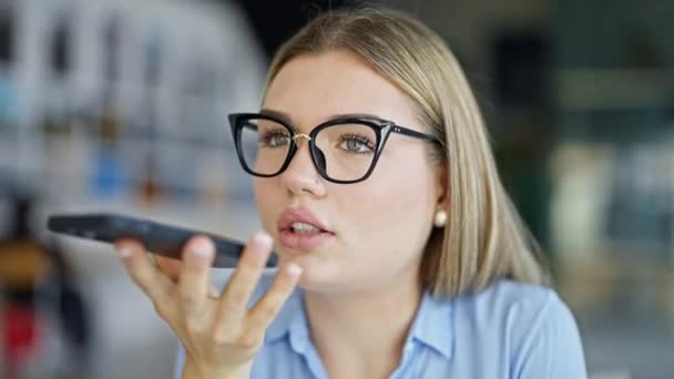 Young blonde woman business worker sending voice message by smartphone working at office - Footage, Video