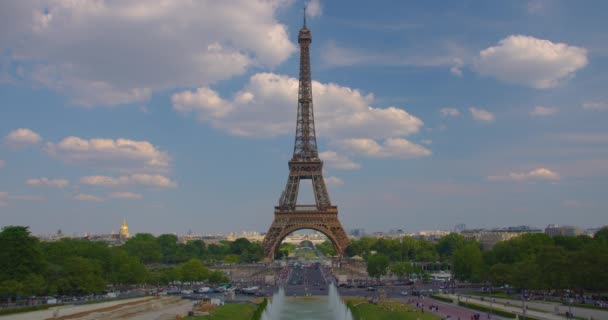 La gente si muove lungo la piazza vicino alla torre. Vista dell'attrazione più visitata di Parigi è la Torre Eiffel. Molta gente cammina nel centro di Parigi. Editoriale. - Filmati, video