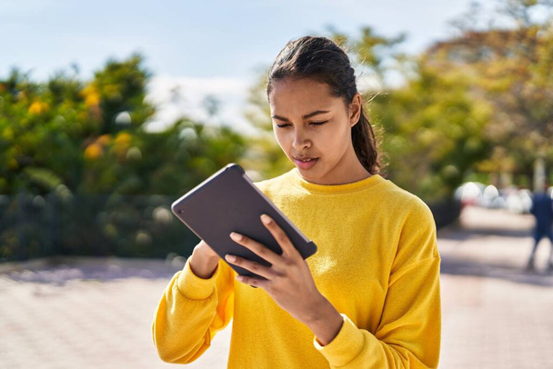 Νεαρή Αφροαμερικανή που χρησιμοποιεί touchpad στο πάρκο - Φωτογραφία, εικόνα