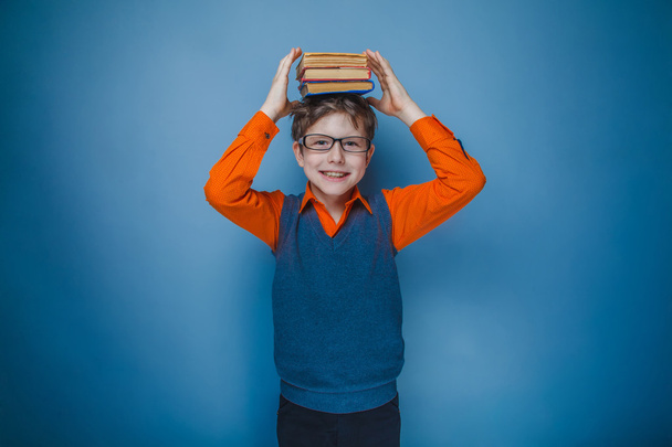 European-looking boy of ten years in glasses with books on her h - Foto, Imagen