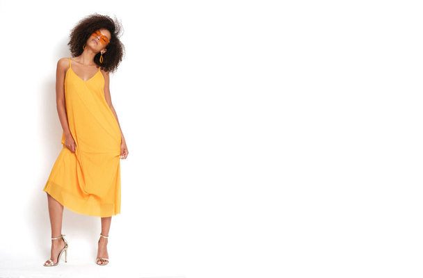 Muito atraente jovem mulher com penteado afro e vestido amarelo no fundo branco isolado. - Foto, Imagem