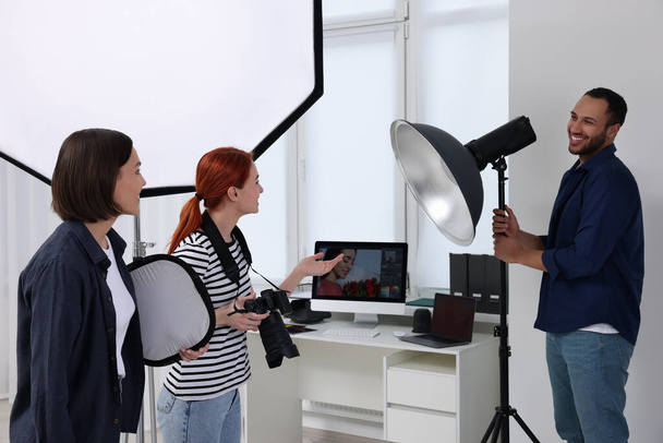 Young professional photographers working in modern photo studio - Photo, image