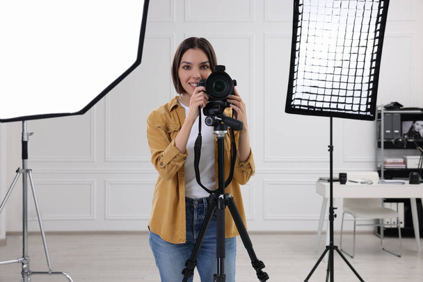 Professional photographer working with camera in modern photo studio - Фото, изображение
