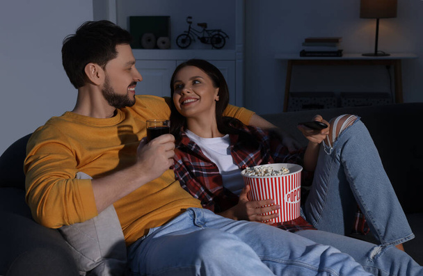 Happy couple spending time near TV at home in evening - Φωτογραφία, εικόνα