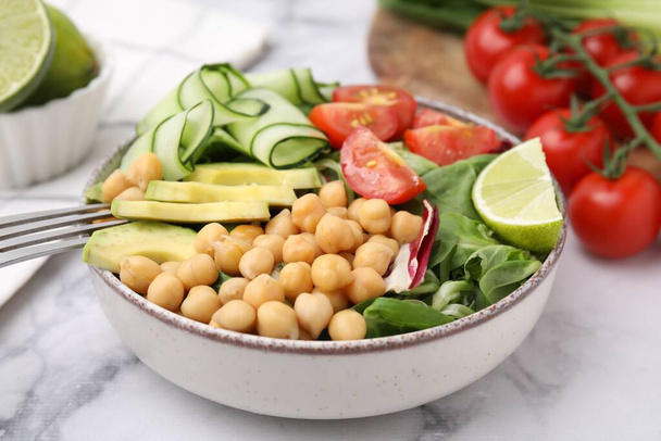 Tasty salad with chickpeas and vegetables on white marble table, closeup - Φωτογραφία, εικόνα