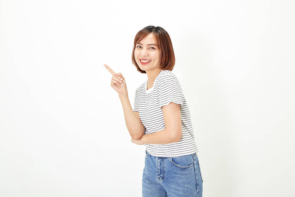 Charming young Asian businesswoman with a short brunette wearing a t-shirt and jeans standing on a white background copy space - Photo, Image