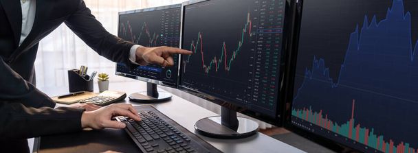 Group of traders discussing on office desk, monitoring stock market on monitor at office workplace. Businessman and broker analyzing stock graph together at stock trading company. Trailblazing - Foto, Imagem