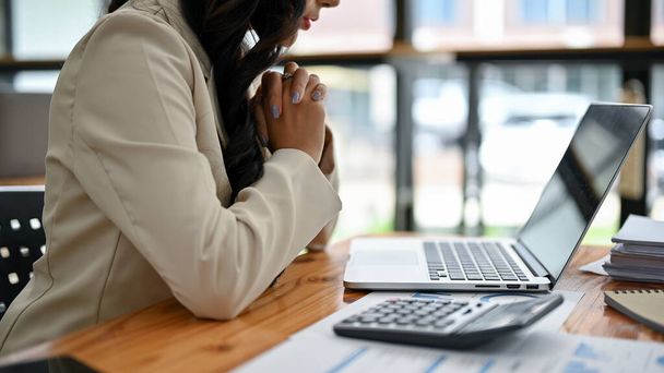 Close-up imagem vista traseira de uma empresária asiática profissional se concentra em suas tarefas em seu laptop, analisando dados financeiros de negócios, e trabalhando em sua mesa no escritório. - Foto, Imagem