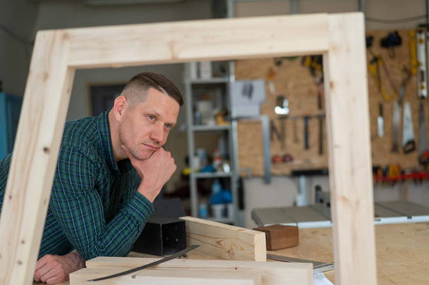 Portrait of a pensive caucasian man in a workshop - Foto, Imagen