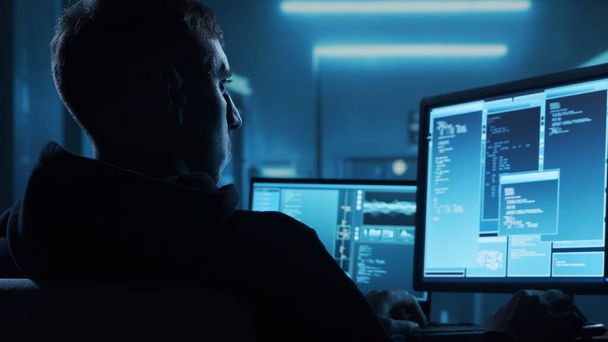 Computer Hacker in Hoodie. Obscured Dark Face. Hacker Attack, Virus Infected Software, Dark Web and Cyber Security concept. - Foto, Imagen