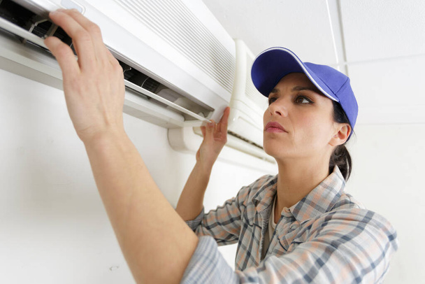 female operator inspecting air conditioning - Фото, изображение