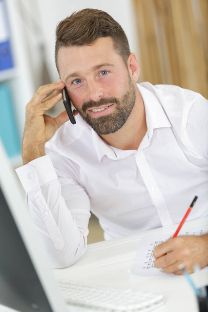 businessman shopping over the phone in an office - Φωτογραφία, εικόνα