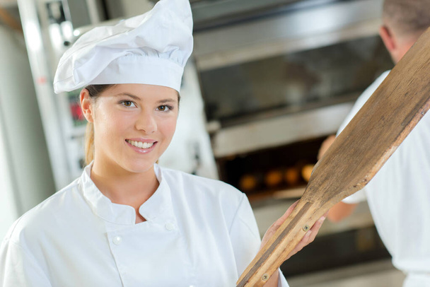 a woman baker posing in kitchen - Foto, Bild