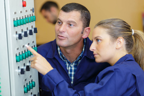 apprentice being shown electronic control panel in factory - Фото, зображення