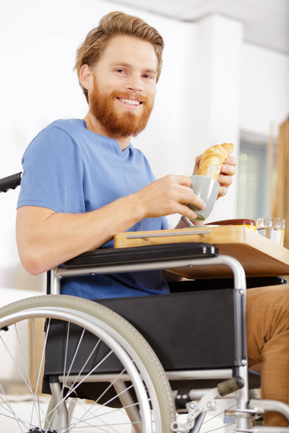 man in wheelchair is ready to have food at home - Zdjęcie, obraz