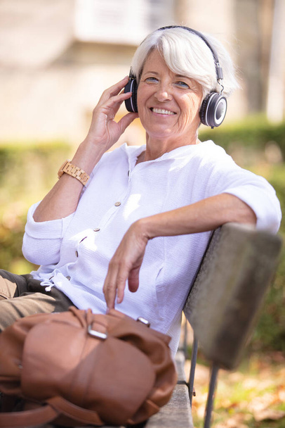幸せな先輩女ヘッドフォンで音楽を聴く - 写真・画像