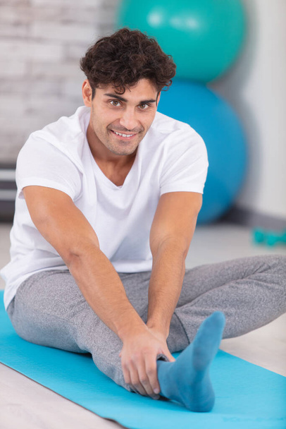 handsome young man doing hamstring stretch exercise - Foto, imagen