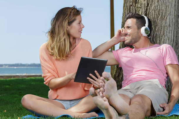 couple in the park looking at tablet - Photo, Image