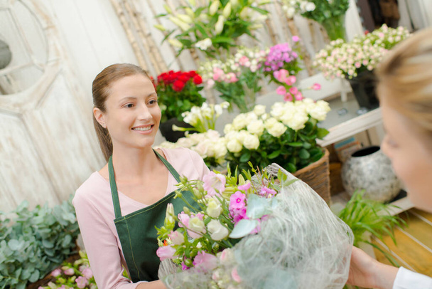 Florist selling a bunch of flowers - Фото, зображення