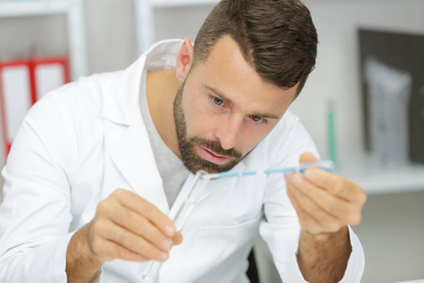 concentrated middle-aged researcher using pipette - 写真・画像