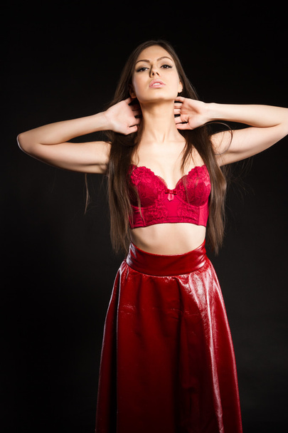 Girl in red long skirt and bra. studio photography - Foto, Imagen