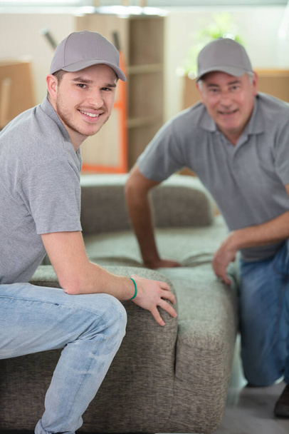 men delivering a new sofa to a property - Foto, afbeelding