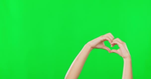 Hart, handen en vorm met kind op groen scherm voor liefde, steun en motivatie. Emoji, romantiek en positieve gebaar met close-up van kind op studio achtergrond voor stem, vriendelijkheid en Valentijnsdag. - Video