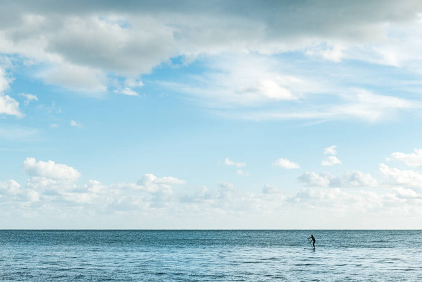 Stand up paddle on tranquil blue sea, surrounded by natures beauty. - Photo, image