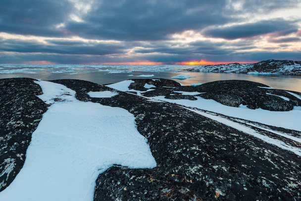 Coucher de soleil sur le paysage côtier avec des icebergs dans le fjord - Photo, image