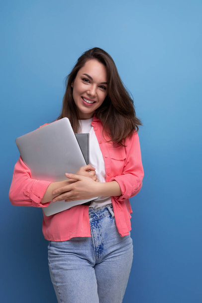 fiduciosa bruna giovane donna d'affari in camicia e jeans con computer portatile. - Foto, immagini
