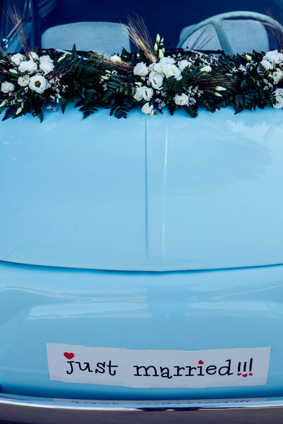 eine Nahaufnahme eines Hochzeitswagens mit lustigem Text  - Foto, Bild