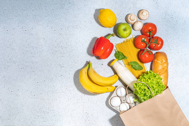 Fresh vegetables, meat, bread fruits in paper grocery bag. Grocery delivery healthy food background. Healthy food cooking ingredients on white, background, Shopping food supermarket banner - 写真・画像