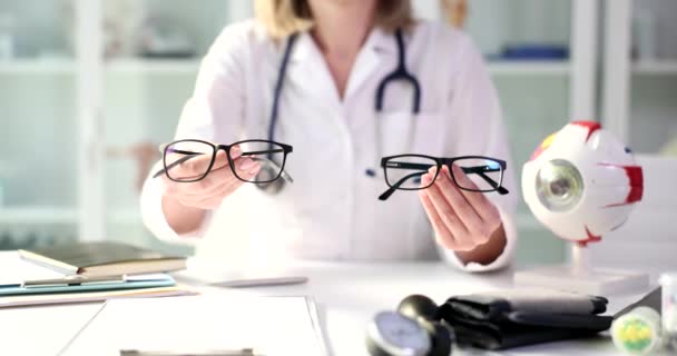 眼科医は視力のための眼鏡のモデルを示しています。近視と近視の禁欲主義 - 映像、動画