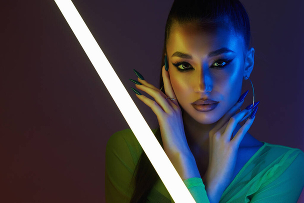beautiful young woman with neon lamp. Pretty girl in color lights. studio portrait - Zdjęcie, obraz