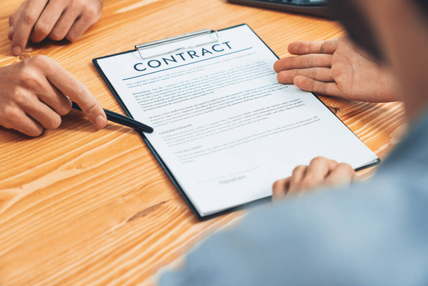 Biznesmen starannie przegląda dokumenty kontraktowe dla spółki osobowej. Umowa lektury umowy z klientem i warunki dotyczące stołu spotkań dla profesjonalnej decyzji biznesowej. Podmiot - Zdjęcie, obraz