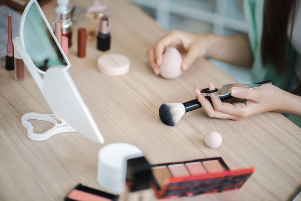 Beauty influencer Asian girl makeup artist recommending foundation cosmetic. - Zdjęcie, obraz