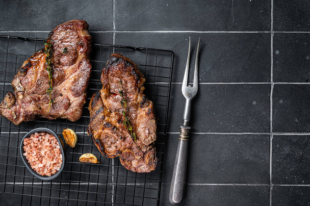 BBQ Grilled Pork loin steaks, neck meat. Black background. Top view. Copy space. - Photo, Image
