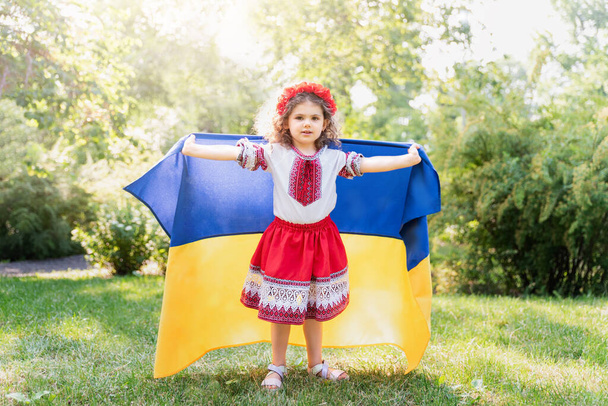 Ukraines Independence Flag Day. Constitution day. Ukrainian child girl in embroidered shirt vyshyvanka with yellow and blue flag of Ukraine in field. flag symbols of Ukraine. Kyiv, Kiev day - Fotó, kép